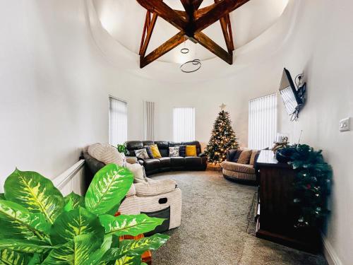 a living room with a couch and a christmas tree at Sea View Penthouse - Regency Mansion in Redcar