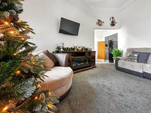 a living room with a christmas tree and a couch at Sea View Penthouse - Regency Mansion in Redcar