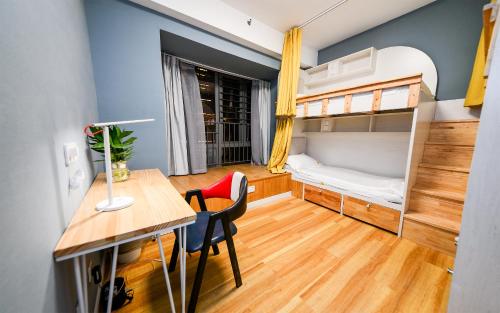 a small room with a desk and a bunk bed at 笑脸里青年旅舍宽窄店 in Chengdu