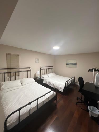 two beds in a room with a desk and a piano at Cozy Home near Downtown, UBC and YVR airport in Vancouver