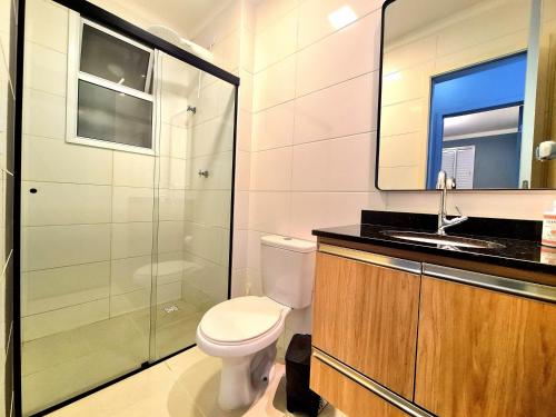 Un baño con inodoro, ducha y lavabo. en Apartamento Ubatuba 405, en Ubatuba