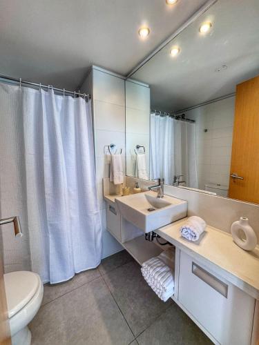 une salle de bain avec un lavabo, des toilettes et un miroir dans l'établissement Torre Bellagio - Piso 17 - Full Amenities - 4 Pax - Piscina Climatizada, à Punta del Este