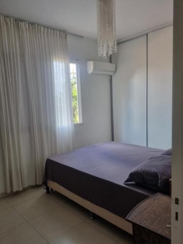 a bedroom with a large bed with a window at Quarto casal privativo in Cuiabá