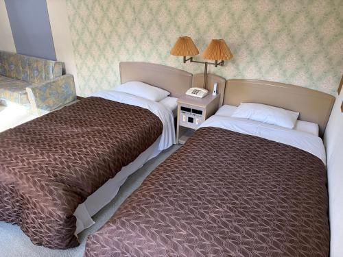a hotel room with two beds and a telephone at フューデイズコンドミニアム定山渓201号室 in Jozankei
