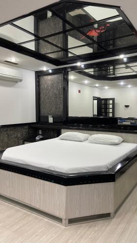 a large bed in a room with a large white mattress at Motel Casa Branca in Blumenau