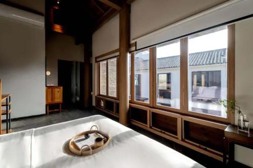 a room with a large bed with a large window at Dali Ancient City Xishan Designer Hotel in Dali Ancient Town