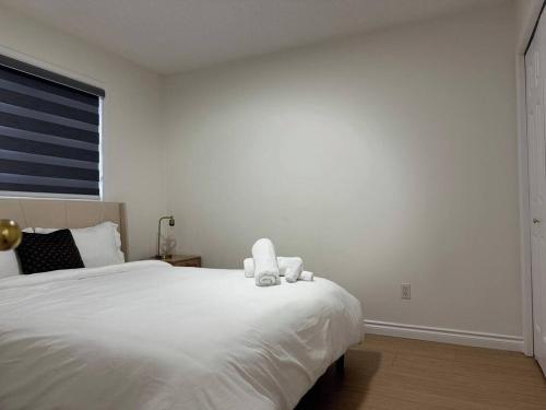 een wit bed met een knuffeldier erop bij Peaceful- King Beds- Attached Garage - Pet Friendly in Edmonton