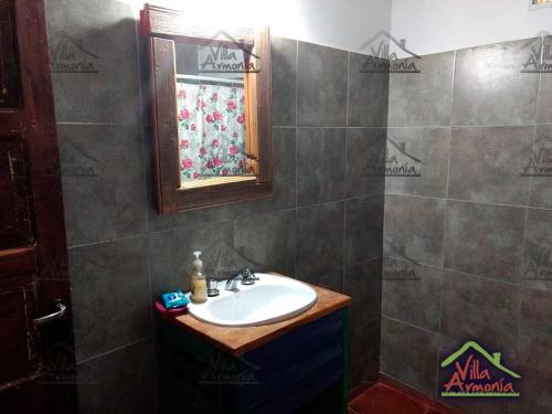 un baño con lavabo y espejo en Villa Armonia, en La Picada