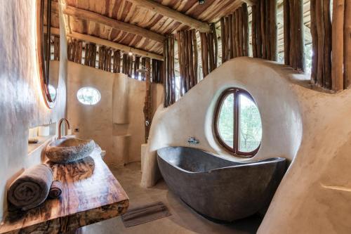 a bathroom with a large tub and a sink at Nuanu Suites & Accommodations in Tanah Lot