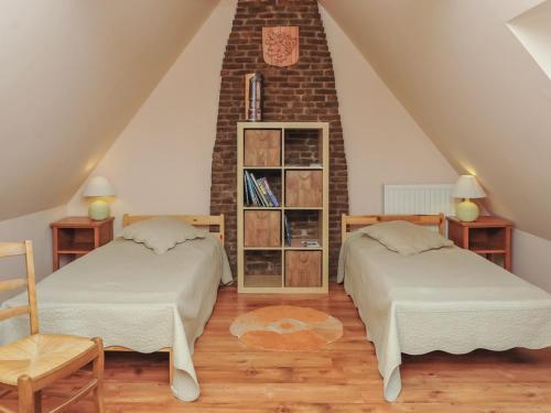 a attic bedroom with two beds and a brick wall at Gîte indépendant près du centre-ville - Animaux acceptés, Parking privé, Wifi - FR-1-510-236 in Steenvoorde