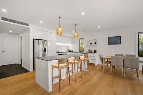 une cuisine et une salle à manger avec des murs blancs et du parquet dans l'établissement Lakefront Luxury 3 Bedroom Apartment, à Wanaka