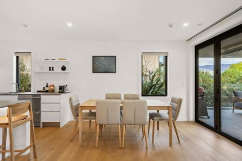 une cuisine et une salle à manger avec une table et des chaises dans l'établissement Lakefront Luxury 2 Bedroom Apartment, à Wanaka
