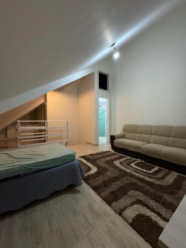 a bedroom with a bed and a couch and a rug at Triplex praia de Caiobá , PR in Matinhos