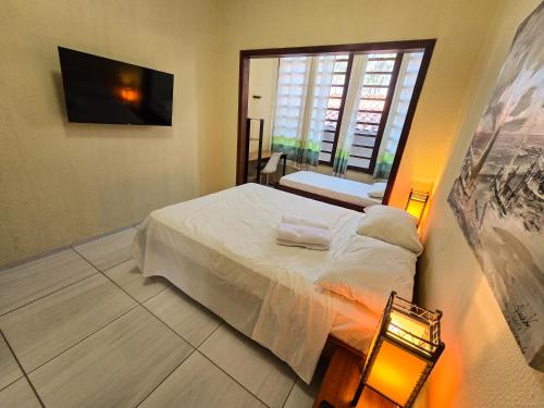 a bedroom with a bed and a large window at Pousada Viva Praia in Paracuru