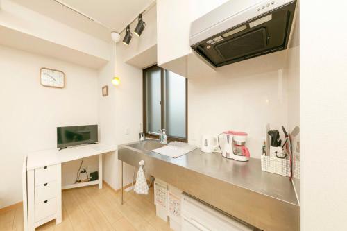 a kitchen with a sink and a counter top at Gamadas BLD in Tokyo