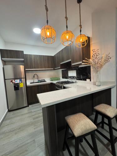 a kitchen with a counter and two stools in it at Hospedaje Tena Matrimonial in Tena