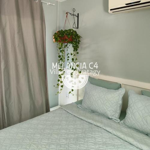 a bedroom with a bed and a hanging plant at Bangalô Melancia C4 in Maceió