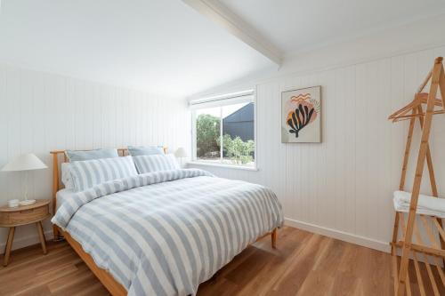 een witte slaapkamer met een bed en een raam bij Magpie Sands - Ocean Views & Seaside Luxury - Steps to beach in Aldinga Beach