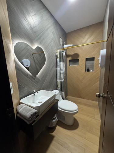 un bagno con un cuore dipinto sul muro di Hospedaje Tena a Tena