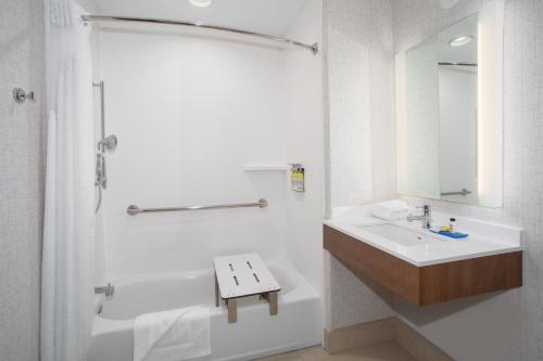 a white bathroom with a sink and a shower at Holiday Inn Express & Suites Phoenix Glendale Dist by IHG in Glendale