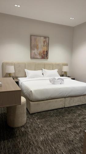 a bedroom with a large bed and two tables at فندق لوسكا in Abha
