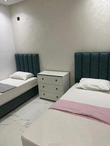 a bedroom with two beds and a dresser in it at Perfect Studio Apartment La Cañada in Fès