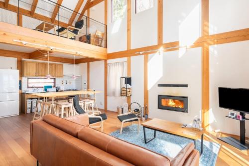 een woonkamer met een bank en een open haard bij Riveret Karuizawa in Karuizawa