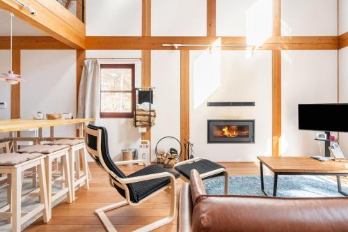 een woonkamer met een bank en een open haard bij Riveret Karuizawa in Karuizawa