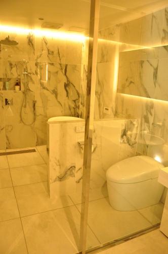 a white bathroom with a toilet and a shower at THE LUGNT - Luxurious private villa surrounded by nature - 