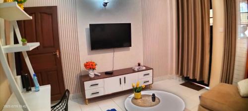 a living room with a television on a wall at Embu Pacific Homes Two Bedroom in Embu
