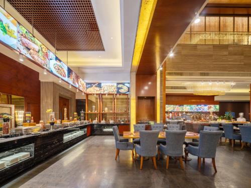 a restaurant with tables and chairs and a bar at Cinese Hotel Dongguan Shijie in Dongguan