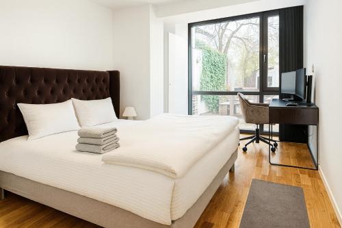 a bedroom with a bed with a desk and a computer at Newly renovated 3 BedRm, Spacious 80m sq, comtemporary Apartment in Central Trendy Oslo-Grunnerlokka in Oslo