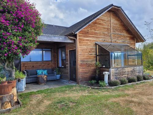 a wooden house with a patio in the yard at Rose Ridge Retreat in Upper Moutere