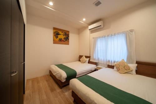 Una pequeña habitación con dos camas y una ventana. en Yufusouin - Vacation STAY 85705, en Yufu