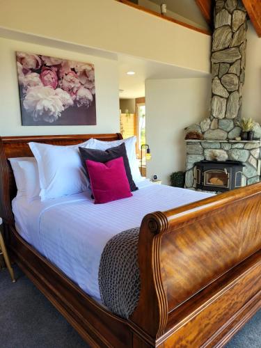a bedroom with a large bed with a stone fireplace at Rose Ridge Retreat in Upper Moutere