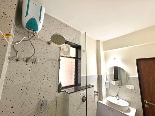 a bathroom with a toilet and a sink and a mirror at Relaxing 2BHK with Mangrove View - Family-Friendly, Pool - Candolim Beach in Candolim