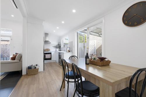 a kitchen and dining room with a large clock on the wall at Courthouse - Family Retreat Near Bendigo CBD in Bendigo