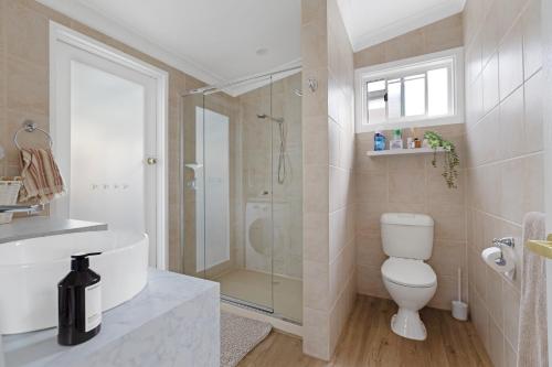 a bathroom with a shower and a toilet and a sink at Courthouse - Family Retreat Near Bendigo CBD in Bendigo