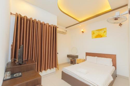 a bedroom with a bed and a television in it at Ngọc Hoa Mai Hotel in Ho Chi Minh City