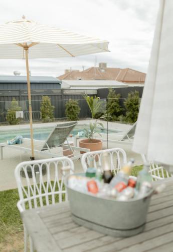 a container of drinks on a table next to a pool at California 'Luxe Boho' with Pool in Echuca
