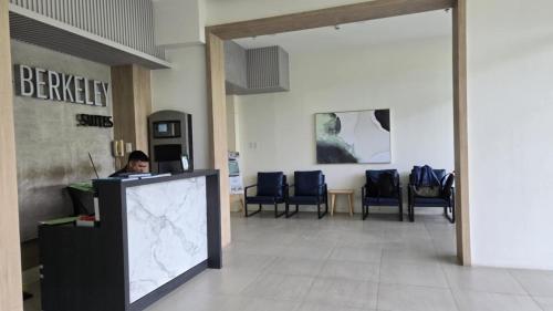 a person sitting at a desk in a lobby at Urban Oasis Cozy Studio at Berkeley Suites South Forbes Nuvali in Silang