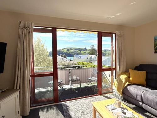 ein Wohnzimmer mit Couch und großem Fenster in der Unterkunft Seaview Akaroa in Akaroa