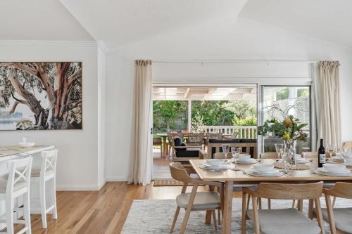 a white dining room with a table and chairs at Crestmount in Milton