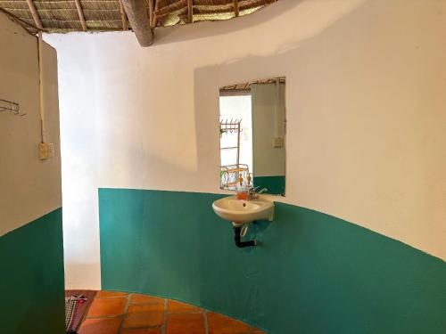 ein Badezimmer mit Waschbecken und Spiegel in der Unterkunft Bohemiaz Resort and Spa Kampot in Kampot