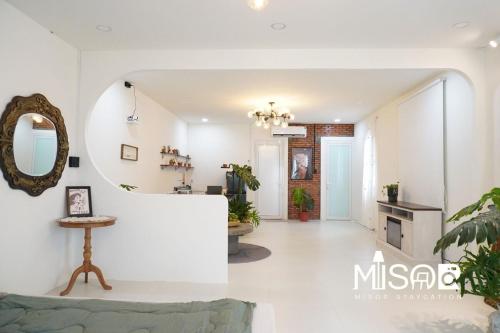 a living room with white walls and a mirror at Chloe's Room 