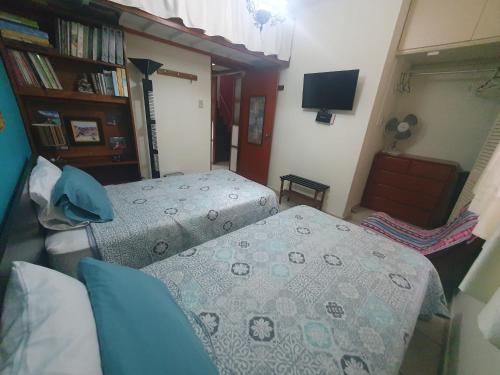 a bedroom with two twin beds and a television at Wilson's Home in Lima