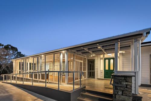 a house with a large deck with glass doors at Deluxe Queen Room at Wolfe Street in Whangarei