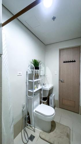 ein weißes Badezimmer mit Toilette und Waschbecken in der Unterkunft SM 3 Cozy Corner Retreat in Sampong