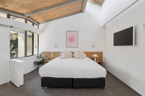 a bedroom with a large bed and a tv at Hibiscus Villa - Beachfront, 2 pools, Tennis, Restaurant in Kororo Basin