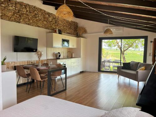 a kitchen and living room with a table and chairs at Cabernet Rural in Sant Jaume dels Domenys